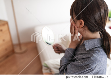 Woman looking in the mirror Woman looking in the mirror 116606203