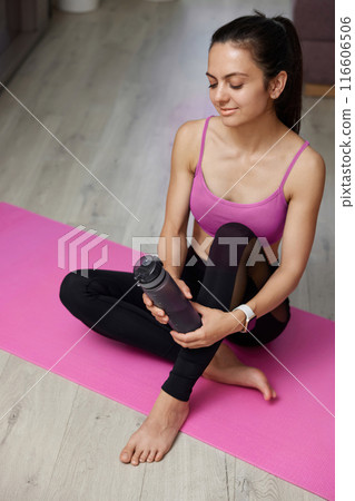 sporty athletic fitness woman in sportswear holding water bottle at home, top view sporty athletic fitness woman in sportswear holding water bottle at home, top view 116606506