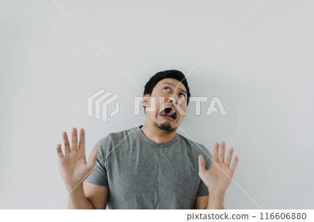 Shocked and disappoint face of man in grey t-shirt isolated on white. 116606880