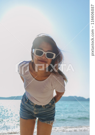 Happy woman enjoy taking photo on sunny beach. Thailand. 116606887