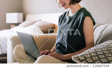 微笑的日本女人在沙發上使用電腦 116607594