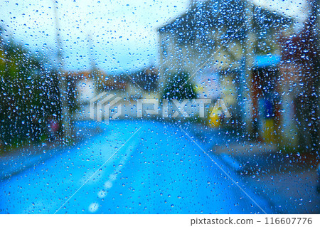 Rain outside window on city background. Water drops on glass during raining 116607776