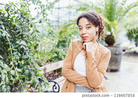 Confident Woman in Greenhouse Garden, Casual Fashion Portrait with Natural Background Confident Woman in Greenhouse Garden, Casual Fashion Portrait with Natural Background 116607858