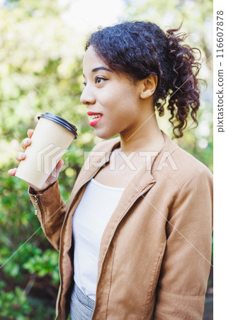 Young Woman Drinking Coffee Outdoors, Enjoying Nature, Spring Morning Stroll, Casual Outfit. 116607878