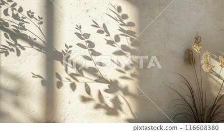 Light Filtering Through Branches and Leaves Against a Cream-Colored Wall 116608380