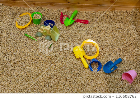 A modern children's sandbox with toys. Sandbox filler in the form of wooden small wood pellets A modern children's sandbox with toys. Sandbox filler in the form of wooden small wood pellets 116608762