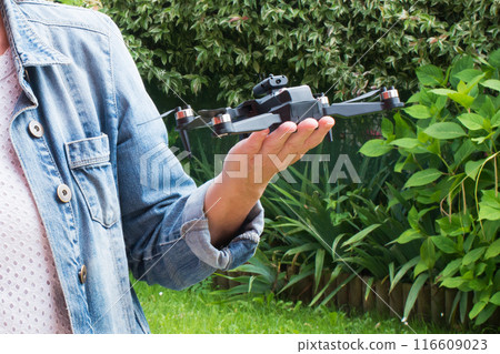 Close up of caucasian woman hand holding a small drone outdoors Close up of caucasian woman hand holding a small drone outdoors 116609023