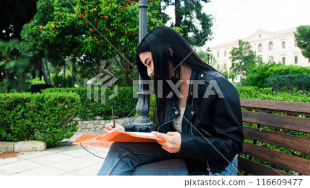 Woman Writing With A Pencil At The Park  116609477