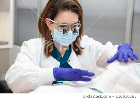 Dermatologist carrying out a skin biopsy on the face of a senior adult patient 116610163