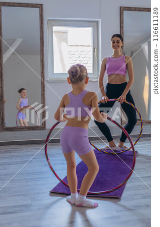 Gymnast child performs an exercise with hoop.Children's professional sports.  116611189