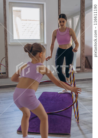 Gymnast child performs an exercise with hoop.Children's professional sports.  116611190