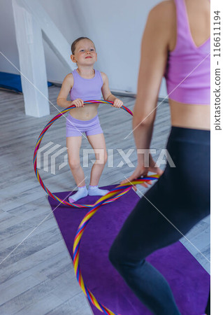 Gymnast child performs an exercise with hoop.Children's professional sports.  116611194