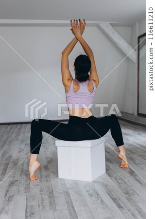 Sporty flexible girl doing stretching exercise 116611210