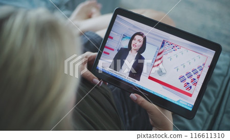 Tablet screen shows news broadcast about US elections with female newscaster Tablet screen shows news broadcast about US elections with female newscaster 116611310