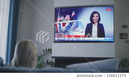 Young girl comes into room and sits on sofa near mother 116611373