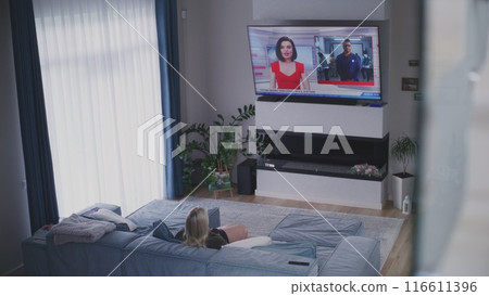 Young girl comes into room and sits on sofa near mother Young girl comes into room and sits on sofa near mother 116611396
