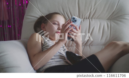 Caucasian teenager uses her mobile phone to surf Internet Caucasian teenager uses her mobile phone to surf Internet 116611706
