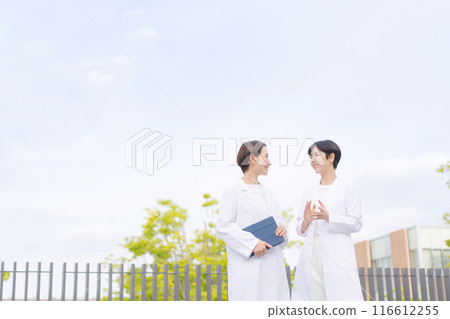 身穿白大褂的婦女在醫院屋頂上交談 116612255