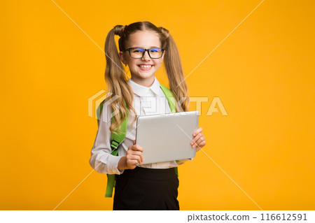 Schoolgirl Holding Digital Tablet On Yellow Background In Studio. Copy Space Schoolgirl Holding Digital Tablet On Yellow Background In Studio. Copy Space 116612591