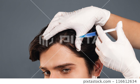 Mesotherapy of hair. Young man getting injections in head, grey panorama background, empty space 116612634