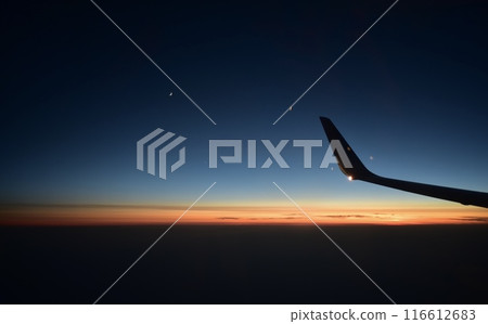 Sunset seen from an airplane window Sunset seen from an airplane window 116612683