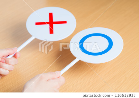 A person holding a plate with circles and crosses 116612935