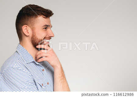 Young millennial man looking away at copy space and smiling, panorama, free space, grey studio background 116612986
