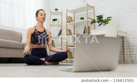 Self learning. Woman using laptop to training yoga online in living room Self learning. Woman using laptop to training yoga online in living room 116613563