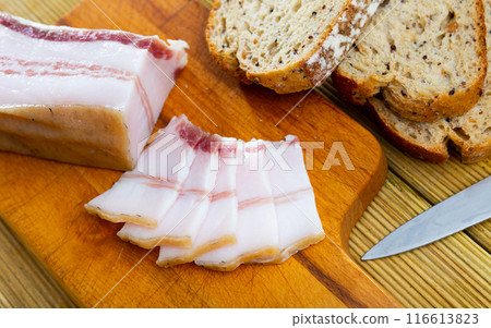 There is pound of lard and several sliced slices on cutting board. 116613823