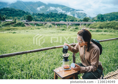 Young Asian woman making a drip coffee while camping in Sapan village of Nan province, Thailand. 116614049