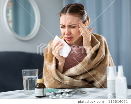 Woman with fever symptoms sitting at home 116614051