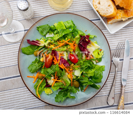 Plate contains portion of salad from fresh seasonal vegetables 116614084