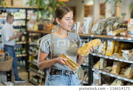 Young girl purchaser buying pasta in grocery store 116614173