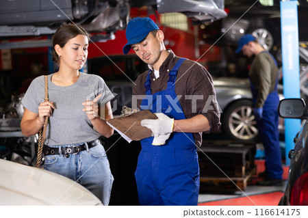 Girl explains the problems of her car to mechanic. Man writes data on paper 116614175
