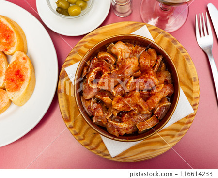 Galician dish of stewed pigs ear with red pepper and potatoes closeup 116614233