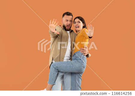 Displeased young couple isolated on orange studio background look at camera denying bad sale offer, dissatisfied unhappy man and woman make gesture say no reject refuse proposal or suggestion Displeased young couple isolated on orange studio background look at camera denying bad sale offer, dissatisfied unhappy man and woman make gesture say no reject refuse proposal or suggestion 116614256