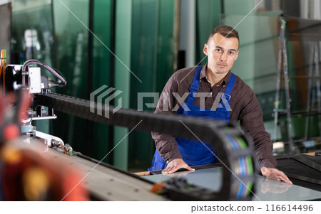 Factory technician processing glass sheet on cutting machine Factory technician processing glass sheet on cutting machine 116614496