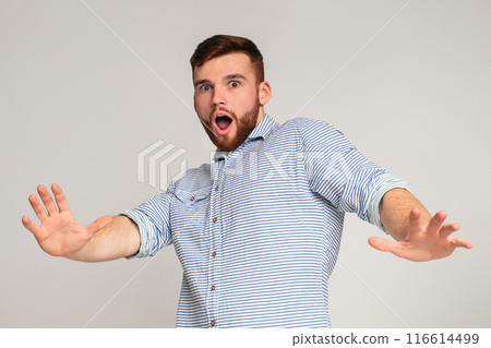I am afraid. Portrait of scared man with open mouth and outstretched hands on studio background, copy space 116614499