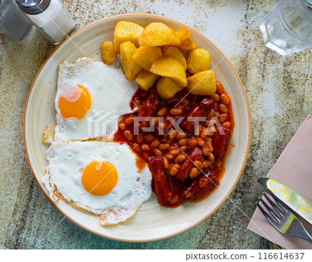English breakfast - scrambled eggs with sausage, beans and boiled potatoes in sauce 116614637