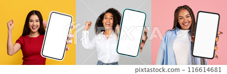 A diverse group of women standing together, each holding a smartphone with a blank screen. They appear engaged with their devices, possibly interacting or viewing content. 116614681
