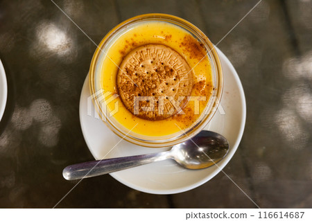 Delicate custard dessert made from milk, eggs and sugar, ornamented with soda biscuit. 116614687
