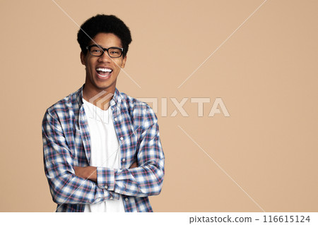 Successful student posing with crossed hands and looking at camera over light background Successful student posing with crossed hands and looking at camera over light background 116615124