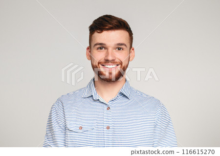 Portrait of smiling bearded millennial guy wearing casual shirt posing isolated on beige studio background 116615270