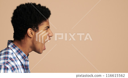 Furious Afro Guy Shouting and Looking at Copy Space over Light Background, Side View 116615562