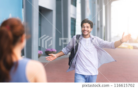 Wife meeting husband at airport terminal, welcoming back home. Man opening arms for hug 116615702
