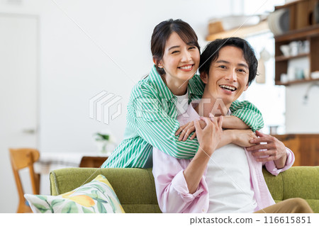一對年輕夫婦在客廳裡放鬆 116615851