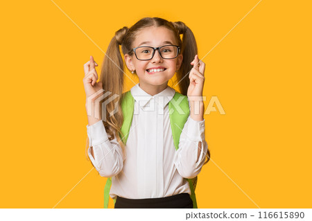 School Girl Keeping Fingers Crossed For Luck Before Test Posing On Yellow Background. Studio Shot 116615890