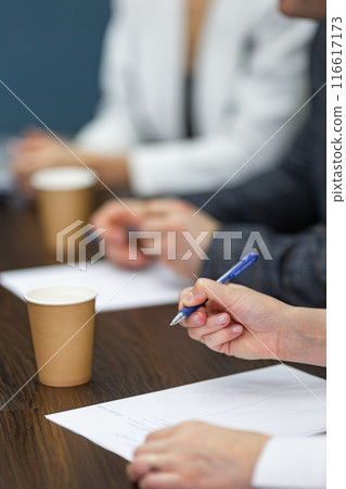 Close-up of a businesswoman's hands with a pen in his hands. 116617173