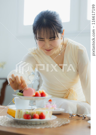 一個女人在咖啡館吃糖果 一個女人在咖啡館吃糖果 116617199