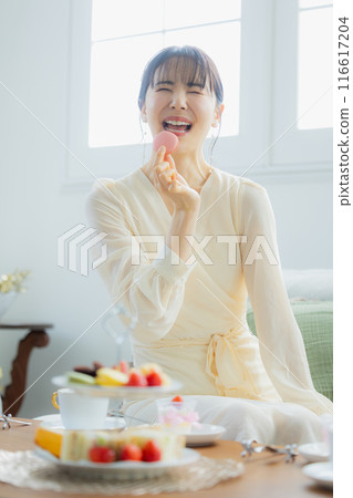 A woman eating sweets at a cafe 116617204
